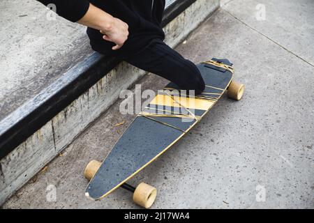 Jeune homme handicapé avec une longue planche dans le parc Banque D'Images