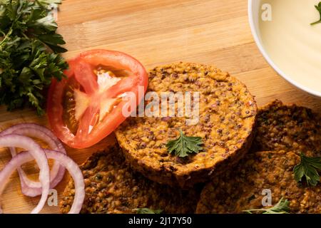 Vue en grand angle des viandes fraîches avec tranche de tomate et rondelles d'oignon sur la table Banque D'Images