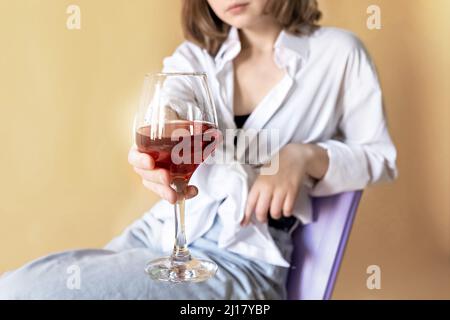 Portrait d'une jeune femme avec un verre de vin rouge entre ses mains. Ressort. Humeur. Banque D'Images