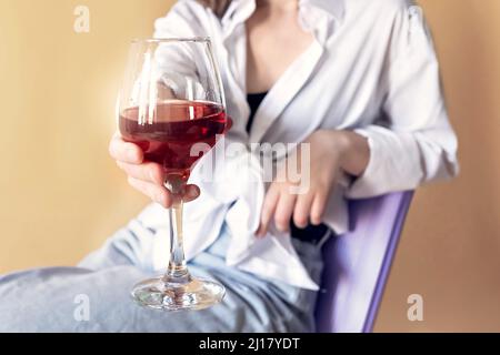 Portrait d'une jeune femme avec un verre de vin rouge entre ses mains. Ressort. Humeur. Banque D'Images