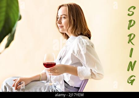 Portrait d'une jeune femme avec un verre de vin rouge entre ses mains. Ressort. Humeur. Banque D'Images