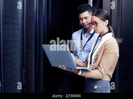 Personne ne connaît les réseaux comme ils le font. Photo de deux techniciens travaillant ensemble dans une salle de serveurs. Banque D'Images