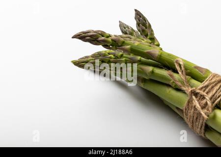 Gros plan à grand angle des asperges attachées avec une ficelle par espace de copie sur fond blanc Banque D'Images