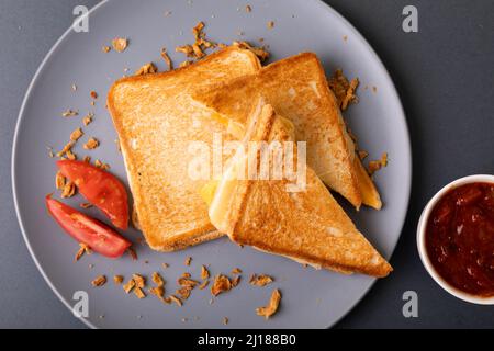 Vue en hauteur d'un sandwich au pain grillé au fromage frais avec tranches de tomate et trempette Banque D'Images