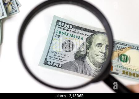 Facture de cent dollars sous une loupe. Vérification de l'argent suspect de la loupe Banque D'Images