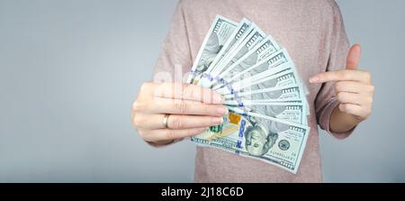 Main de femme coupée tenir le papier Devises ostentaticement le montrant. Le concept obtenir une grande quantité de mone Banque D'Images