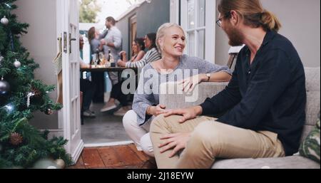 Appréciez-vous la fête ? Photo d'un jeune homme et d'une jeune femme discutant lors d'un dîner avec leurs amis. Banque D'Images
