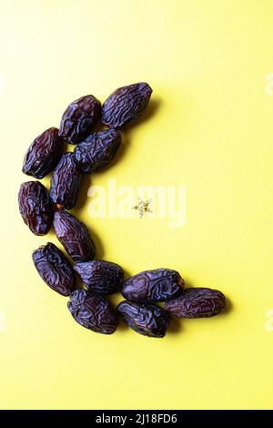 Forme de lune à partir de dates et paillettes brillantes. Vue de dessus. Banque D'Images