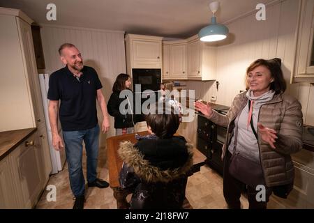 RETRANSMIS AVEC L'ORTHOGRAPHE CORRECTE DES PLATEAUX DE REND Mick Swinhoe montre Iryna Starkova et ses petits-enfants autour de la cuisine de leur nouvelle maison à Caldecote près de Cambridge. La famille des dix personnes âgées de 10 ans, Alikhan, à Ludmila, grande-mère de 90 ans, a fui Kharkiv en Ukraine après l'invasion russe, en commençant leur voyage le 1 mars. Ils ont été aidés par les plateaux de Rend pour trouver une nouvelle maison au Royaume-Uni pour eux et leurs deux chiens Mikki et Florie. Date de la photo: Mardi 22 mars 2022. Banque D'Images
