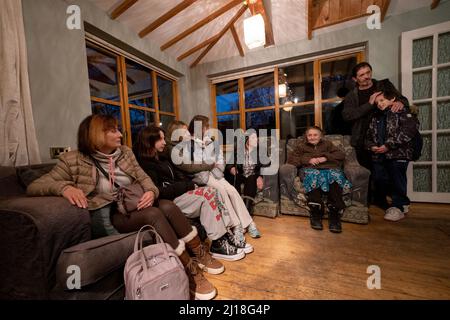 RETRANSMIS AVEC L'ORTHOGRAPHE CORRECTE DES PLAQUES DE REND Iryna Starkova (à gauche) avec sa famille dans leur nouvelle maison à Caldecote près de Cambridge. La famille des dix personnes âgées de 10 ans, Alikhan, à Ludmila, grande-mère de 90 ans, a fui Kharkiv en Ukraine après l'invasion russe, en commençant leur voyage le 1 mars. Ils ont été aidés par les plateaux de Rend pour trouver une nouvelle maison au Royaume-Uni pour eux et leurs deux chiens Mikki et Florie. Date de la photo: Mardi 22 mars 2022. Banque D'Images