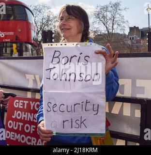 Londres, Royaume-Uni. 23rd mars 2022. Un manifestant tient un panneau qui appelle Boris Johnson un « risque de sécurité ». Le gouvernement anti-conservateur et les manifestants anti-Brexit se sont rassemblés devant le Parlement alors que Boris Johnson était confronté aux questions du Premier ministre. Credit: Vuk Valcic/Alamy Live News Banque D'Images