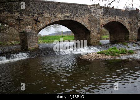 CULMSTOCK, Royaume-Uni - 21 MARS 2021 Culmstock Bridge grade II, bâtiment classé au-dessus de la culme de la rivière à Culmstock, dans le Devon, et un champ vert Banque D'Images