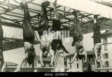 Fascismo - Duce Benito Mussolini - I corpi di Starace, Pavolini, Claretta Petacci, Benito Mussolini e Nicola Bombacci, isseti sulla pensilina del distributore Esso a Milano, à piazzale Loreto - 29 aprile 1945 Banque D'Images