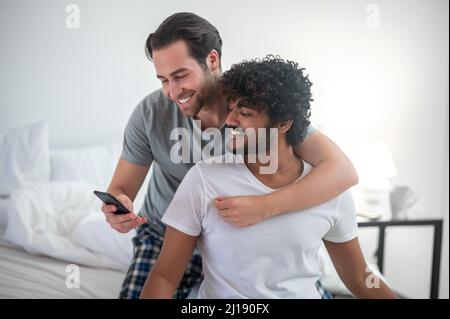 Couple gay romantique posant pour l'appareil photo de smartphone Banque D'Images