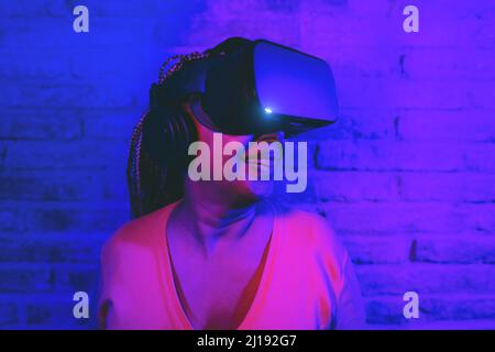 Femme sénior multiraciale s'amusant à l'aide d'un casque de réalité virtuelle - concentrez-vous sur le visage de la femme Banque D'Images