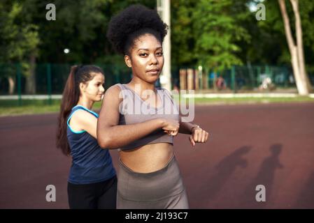 Entraînement étirant les muscles dans l'air frais. Deux belles femmes de forme physique faisant des exercices d'étirement en étirant leurs bras forme physique et style de vie Banque D'Images