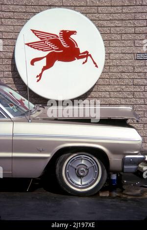 Voiture avec capot élevé à la station-service Mobil de Los Angeles, CA en 1977 Banque D'Images