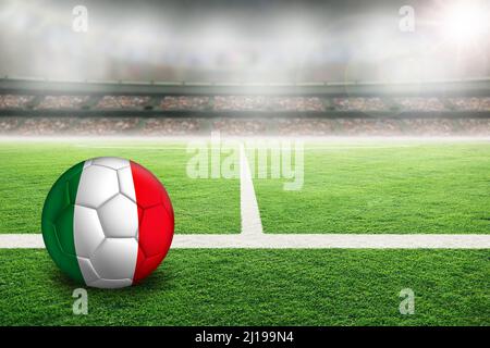 Football dans un stade en plein air lumineux avec drapeau italien peint. Concentrez-vous sur le premier plan et le ballon de football avec une faible profondeur de champ en arrière-plan et co Banque D'Images