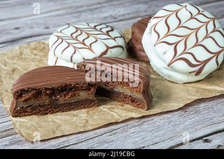 Gros plan du gâteau au miel brésilien coupé en deux. En arrière-plan gâteau brésilien au miel avec glaçage au chocolat blanc. Banque D'Images