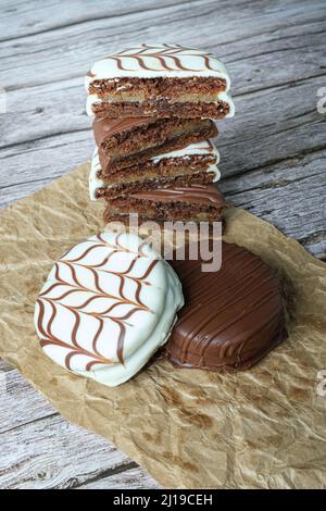 Gâteaux traditionnels au miel brésilien avec glaçage au chocolat blanc. Bourré de dulce de leche. En arrière-plan, plusieurs coupés en deux et empilés verti Banque D'Images