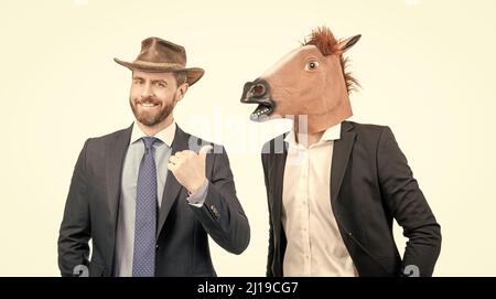 Bon cowboy homme pointe le doigt sur l'homme d'affaires portant la tête de cheval. Partie occidentale. Fête de cowboy Banque D'Images