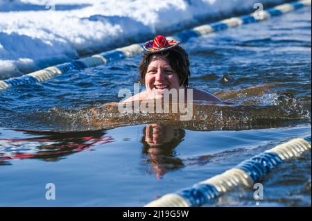 Les baigneurs d'eau froide nagent dans l'eau glacée du lac Memphrémagog près du conseil canadien de Newport, VT, en mars. Banque D'Images