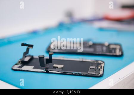 Concept réparation téléphone mobile moderne, maître désassemble le cas pour remplacer écran cassé ou remplacement dégradation de la batterie. Banque D'Images