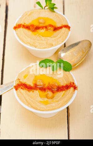 Houmous de pois chiches traditionnels avec de l'huile d'olive à la menthe et du paprika sur le dessus Banque D'Images