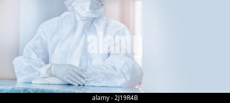 Infirmière clinique dans des combinaisons et des masques de protection dans la zone rouge témoin covid19 bannière coronavirus. Banque D'Images