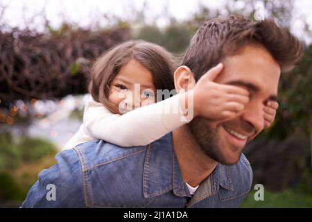 Devinez qui. Une petite fille et son père jouant à l'extérieur. Banque D'Images