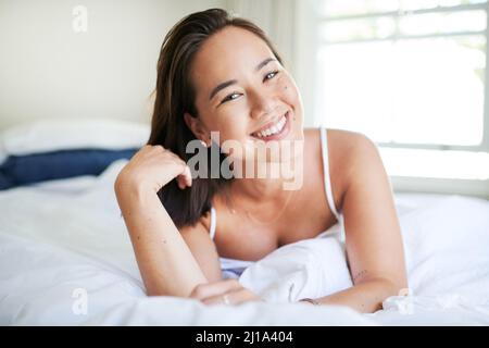 Une bonne nuit de sommeil fait des merveilles. Prise de vue d'une jeune femme attirante couché sur son lit le matin. Banque D'Images