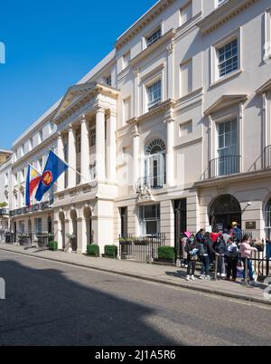 Drapeaux colorés montés sur la façade principale de l'ambassade des Philippines. Les personnes qui font la queue à l'extérieur de la section consulaire. Suffolk Street, Londres, Angleterre, Royaume-Uni Banque D'Images