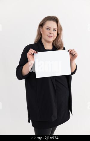 Sourire aux couleurs d'âge moyen gras plus-taille surpoids Plump femme avec maquillage tenant une feuille blanche vierge de papier. Banque D'Images