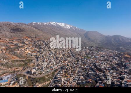 Crête hermon couverte de neige en hiver 2022, avec les maisons de ville de Majd al Shams. Banque D'Images