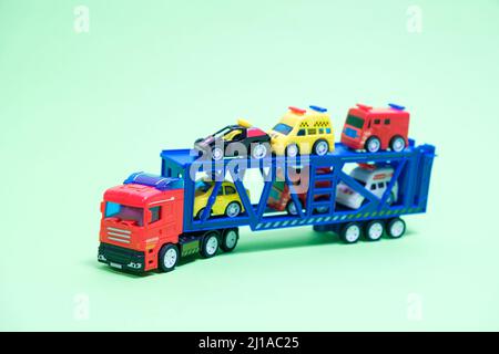 Véhicule de transport en plastique jouet rouge avec équipement spécial à l'intérieur sur fond vert, jouets pour garçons Banque D'Images