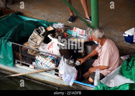 Les vieilles femmes thaïlandaises pagayer et faire de l'équitation bateaux en bois transportant et livrer le produit de réservoir de gaz à la boutique marchande dans le canal local Wat Takhian Floating Banque D'Images