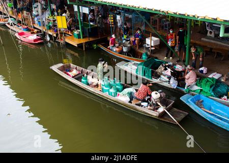 Les vieilles femmes thaïlandaises pagayer et faire de l'équitation bateaux en bois transportant et livrer le produit de réservoir de gaz à la boutique marchande dans le canal local Wat Takhian Floating Banque D'Images