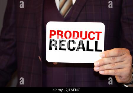 Rappel de produit. Homme tenant une carte avec un texte de message écrit dessus Banque D'Images