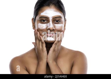 Jeune femme indienne avec un masque de nettoyage appliqué sur son visage Banque D'Images