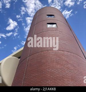 grand rond brique rouge bâtiment de forme de cheminée regardant en dessous du ciel bleu et des nuages blancs angle inhabituel de la structure cylindrique Banque D'Images
