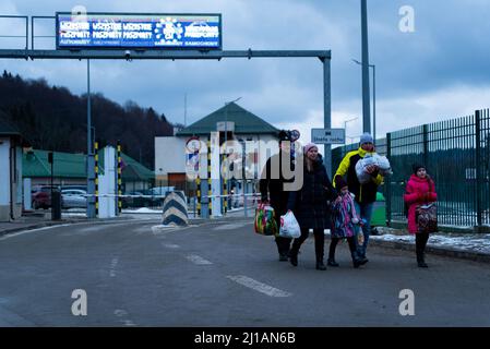 Une famille avec des enfants est vue marcher le 5 mars 2022, après le passage de la frontière entre l'Ukraine et la Pologne à Kroscienco, en Pologne. Plus d'un million Banque D'Images