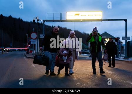 Une famille avec des enfants est vue marcher le 5 mars 2022, après le passage de la frontière entre l'Ukraine et la Pologne à Kroscienco, en Pologne. Plus d'un million Banque D'Images
