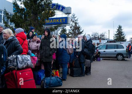 Les réfugiés d'Ukraine attendent dans la ligne alors qu'ils traversent la frontière entre la Pologne et l'Ukraine et fuient la guerre Russie-Ukraine à Shepyni, en Ukraine, le 8 mars 2022. Plus Banque D'Images