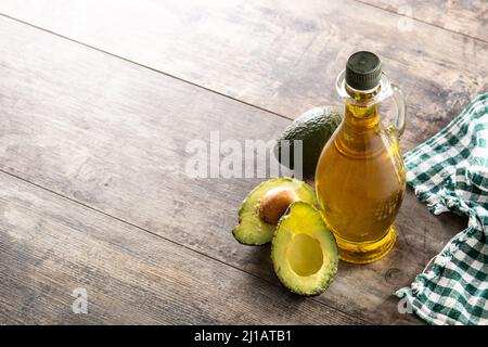 Huile et avocat frais mûr sur une table rustique en bois Banque D'Images