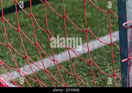filet rouge d'un but de football d'un terrain de gazon artificiel Banque D'Images