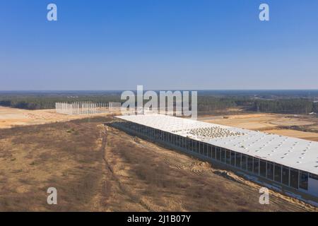 Vaste plaine, chantier de construction, construction d'un grand hall industriel. Vue depuis le drone. Banque D'Images