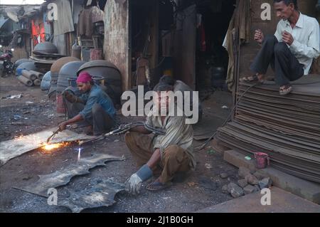 Soudeurs au travail dans un chantier de démolition situé dans un bidonville de Darukhana, Byculla, Mumbai, Inde Banque D'Images