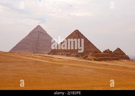 Vue sur la vallée de Gizeh dans le désert du Sahara au Caire, en Égypte, avec la Grande Pyramide de Gizeh en ciel nuageux. Banque D'Images