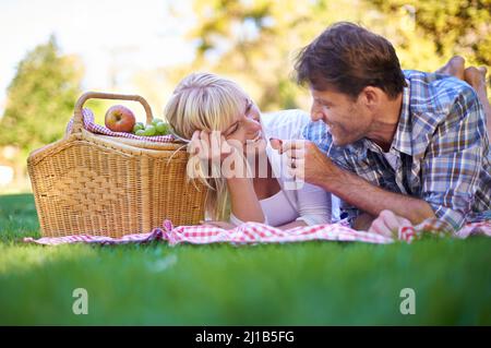 Ouvrez. Photo d'un couple affectueux en train de pique-niquer au soleil. Banque D'Images