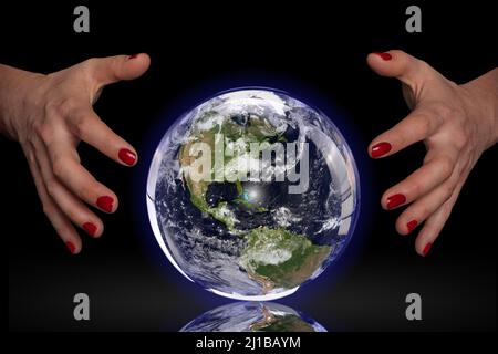 PHOTO CONCEPTUELLE MONTRANT LA TERRE DANS UNE BOULE DE CRISTAL POUR PRÉDIRE POUR ELLE UN AVENIR MEILLEUR, EXPOSITION DE PHOTO «TERRE FRAGILE» POUR SENSIBILISER À L'IMPACT DE L'HUMANITÉ SUR LA PLANÈTE, LA FRANCE, LE MONDE Banque D'Images